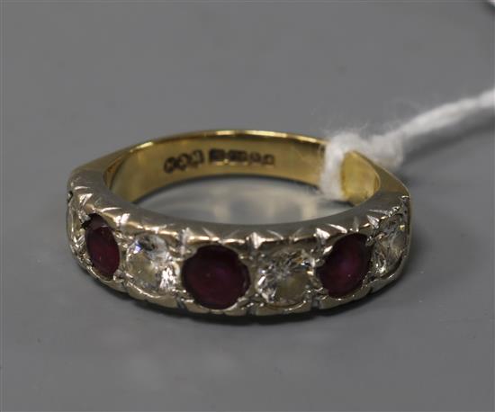 A modern 18ct gold, ruby and diamond seven stone half hoop ring, size Q.